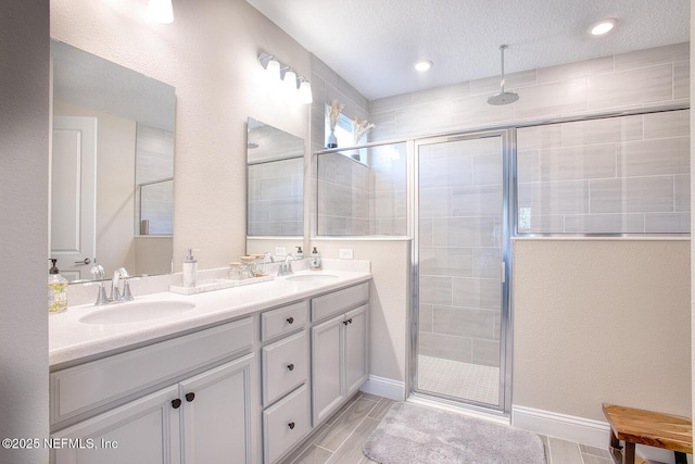 bathroom featuring vanity, a textured ceiling, and walk in shower