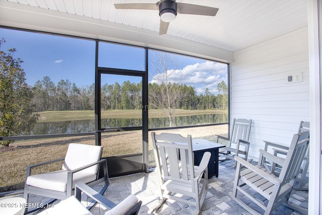 sunroom / solarium featuring a water view and ceiling fan