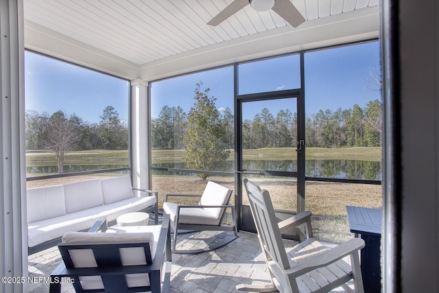 sunroom / solarium featuring a water view and ceiling fan