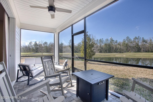 sunroom / solarium featuring a water view and ceiling fan