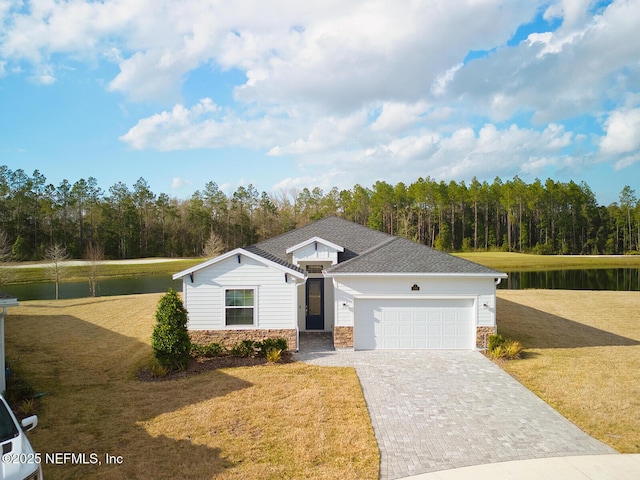 view of front of property with a garage, a front yard, and a water view