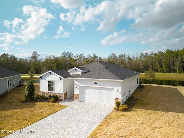 single story home featuring a garage, a water view, and a front lawn