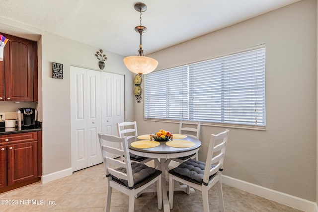 dining space featuring light tile patterned floors and baseboards