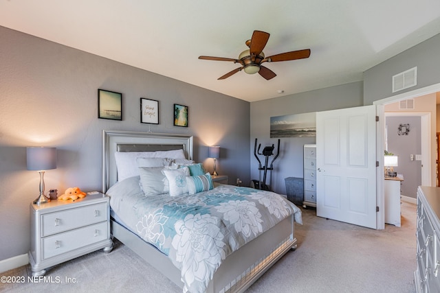 bedroom featuring baseboards, a ceiling fan, visible vents, and light colored carpet