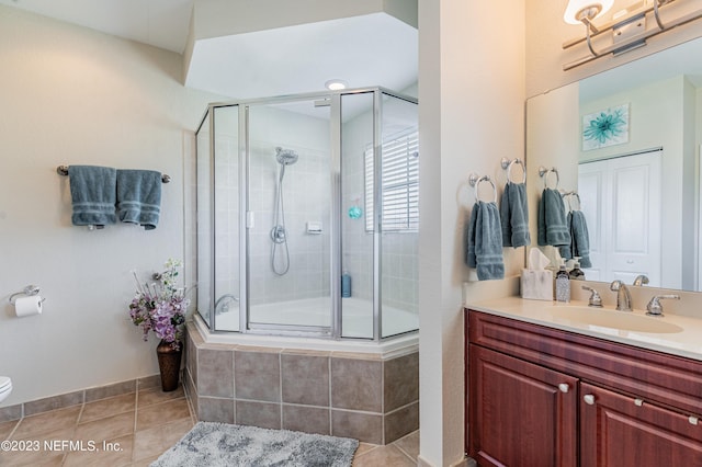 bathroom with toilet, tile patterned flooring, a tile shower, and vanity