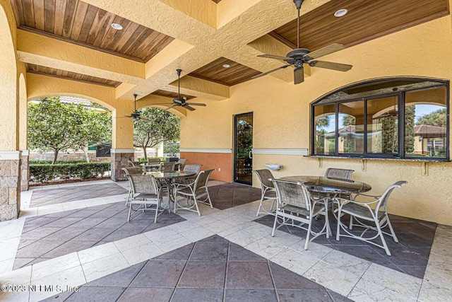 view of patio with outdoor dining area and a ceiling fan