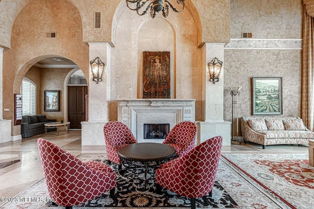 interior space with visible vents, a fireplace, and a towering ceiling