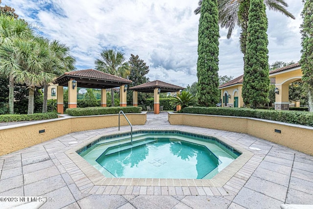 view of pool with a patio area, a community hot tub, and a gazebo