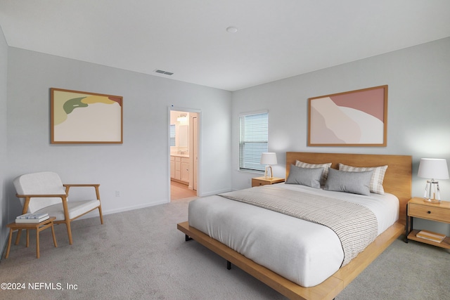 carpeted bedroom featuring ensuite bath