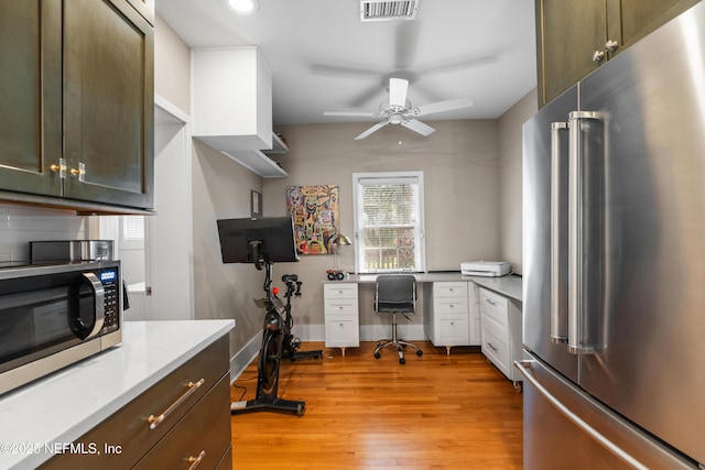 kitchen featuring stainless steel appliances, ceiling fan, and light wood-type flooring