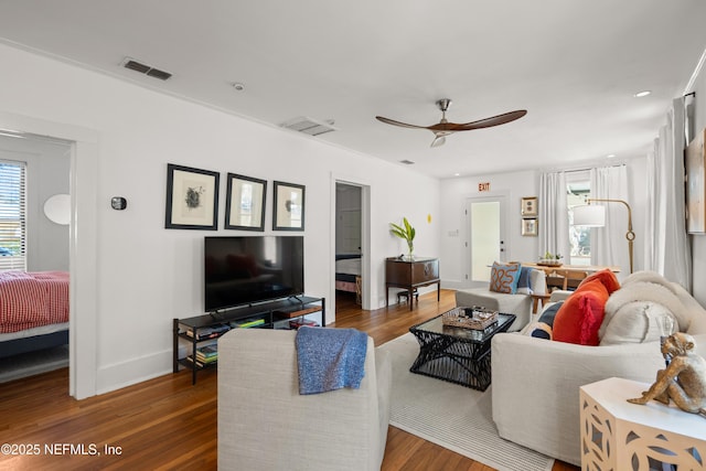 living room featuring dark wood-type flooring and ceiling fan