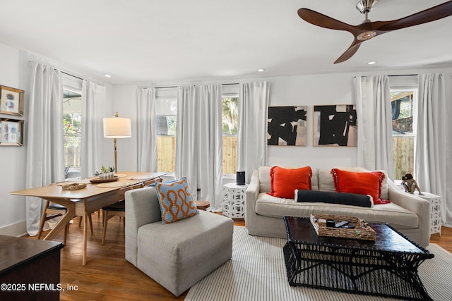 living room featuring hardwood / wood-style flooring, a healthy amount of sunlight, and ceiling fan