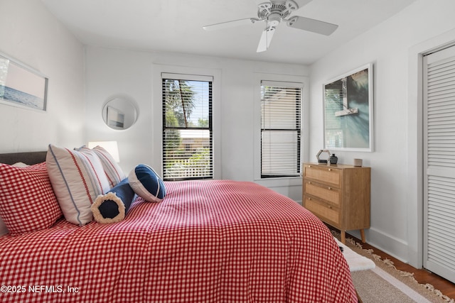 bedroom with ceiling fan, wood-type flooring, and a closet