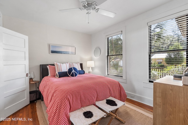 bedroom featuring multiple windows, ceiling fan, and dark hardwood / wood-style flooring