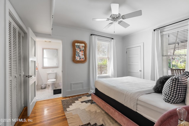 bedroom with ensuite bathroom, crown molding, a closet, ceiling fan, and light hardwood / wood-style floors