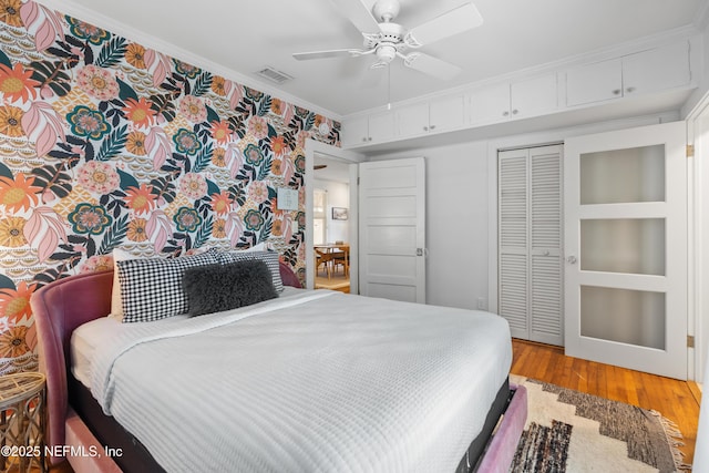 bedroom featuring crown molding, ceiling fan, hardwood / wood-style floors, and a closet