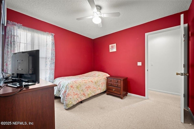 bedroom featuring light carpet, ceiling fan, and a textured ceiling