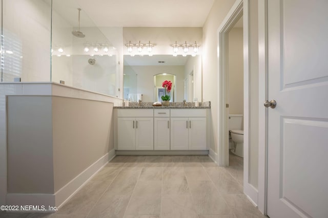 bathroom featuring vanity, toilet, and a shower