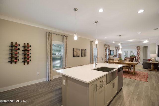 kitchen featuring sink, crown molding, dishwasher, an island with sink, and decorative light fixtures