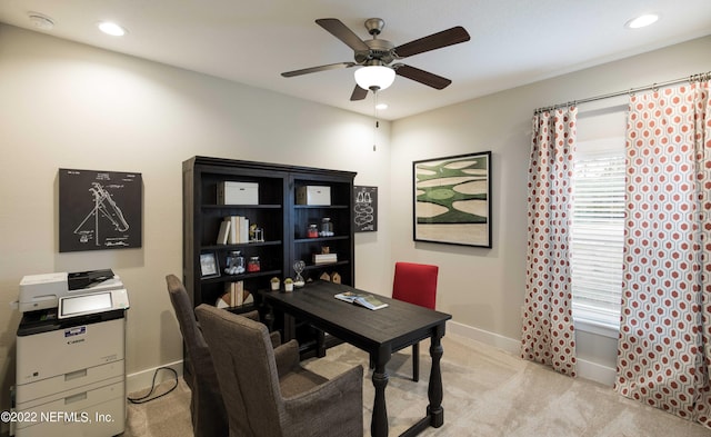 carpeted home office featuring ceiling fan