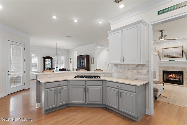 kitchen featuring pendant lighting, open floor plan, light countertops, and gray cabinets