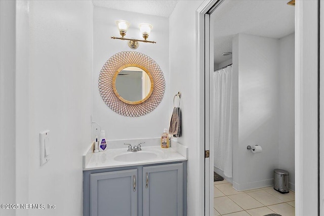 bathroom featuring a textured ceiling, tile patterned flooring, vanity, and baseboards