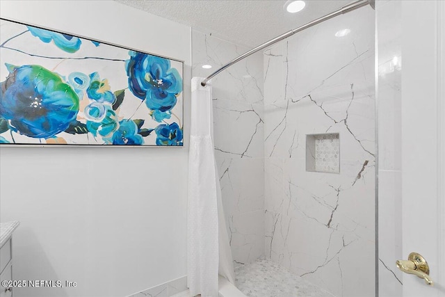 bathroom featuring a marble finish shower and a textured ceiling