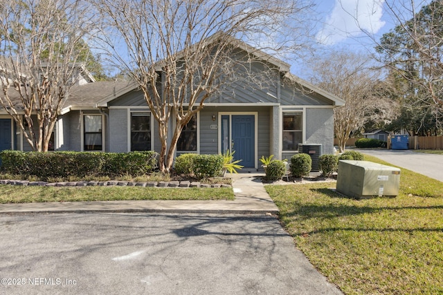 view of front facade featuring a front yard and central air condition unit