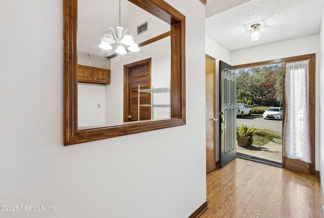 10800 Old St Augustine Rd Unit 301, Jacksonville, FL 32257 - entryway featuring an inviting chandelier, a textured ceiling, and light wood-type flooring