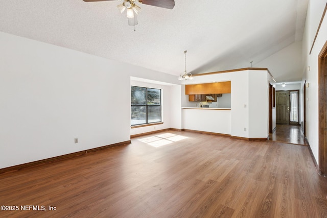 10800 Old St Augustine Rd Unit 301, Jacksonville, FL 32257 - unfurnished living room featuring vaulted ceiling, wood-type flooring, ceiling fan with notable chandelier, and a textured ceiling