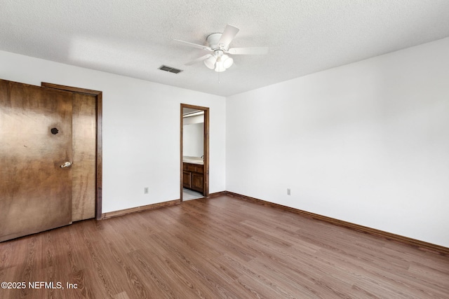 10800 Old St Augustine Rd Unit 301, Jacksonville, FL 32257 - unfurnished bedroom featuring ensuite bath, a textured ceiling, and light wood-type flooring