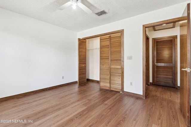 10800 Old St Augustine Rd Unit 301, Jacksonville, FL 32257 - unfurnished bedroom with wood-type flooring, ceiling fan, a textured ceiling, and a closet