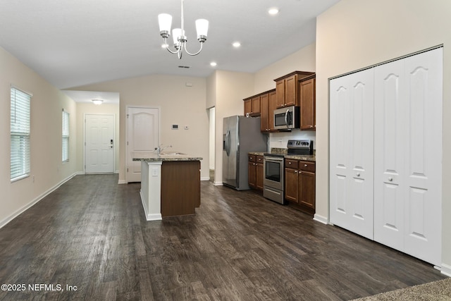 kitchen with dark wood-type flooring, lofted ceiling, appliances with stainless steel finishes, an island with sink, and light stone countertops