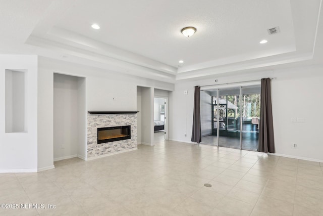 944 Laurel Valley Dr, Orange Park, FL 32065 - unfurnished living room with a raised ceiling, a stone fireplace, recessed lighting, and light tile patterned floors