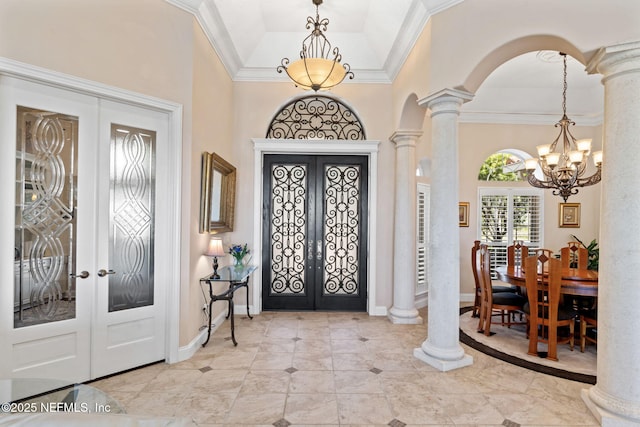 tiled entrance foyer with arched walkways, french doors, decorative columns, and crown molding