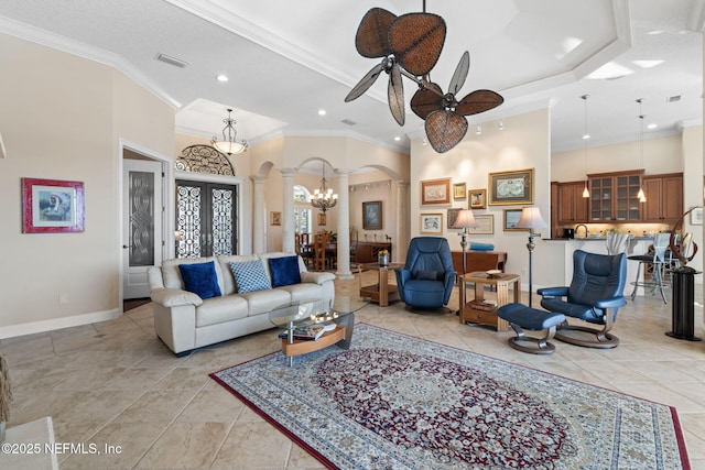 living room with arched walkways, visible vents, crown molding, and a towering ceiling