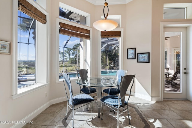 dining space with ornamental molding, a sunroom, and baseboards