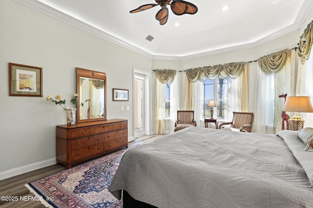 bedroom featuring visible vents, baseboards, a raised ceiling, wood finished floors, and recessed lighting