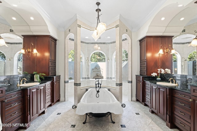 full bath with a freestanding bath, two vanities, and a sink