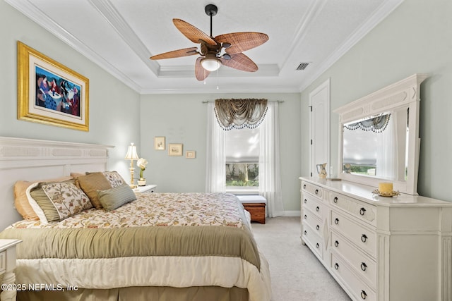 bedroom featuring ornamental molding, a tray ceiling, visible vents, and light colored carpet