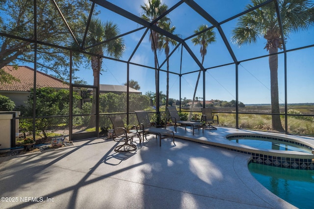 outdoor pool featuring a lanai, a patio, and an in ground hot tub