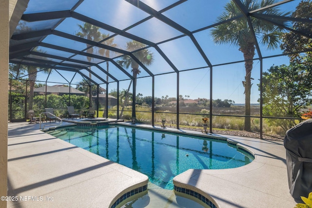 view of pool with a patio area, a pool with connected hot tub, and glass enclosure