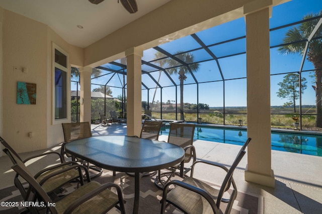 exterior space featuring a lanai, ceiling fan, and an outdoor pool