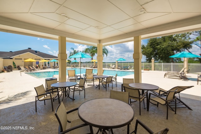 view of patio with fence and a community pool