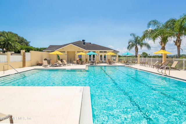 pool with a patio area and fence