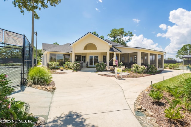 view of front of property with a sunroom, a gate, fence, french doors, and stucco siding