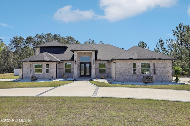 view of front of house featuring brick siding, a front lawn, and french doors