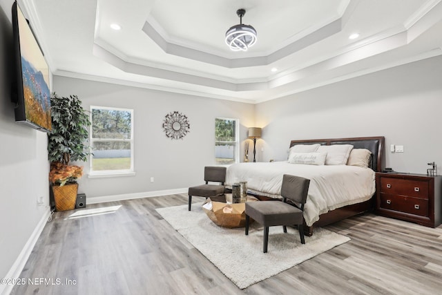 bedroom with recessed lighting, a raised ceiling, ornamental molding, wood finished floors, and baseboards