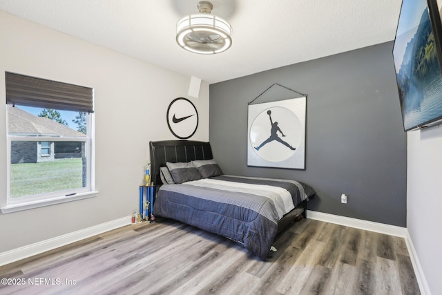 bedroom featuring baseboards and wood finished floors