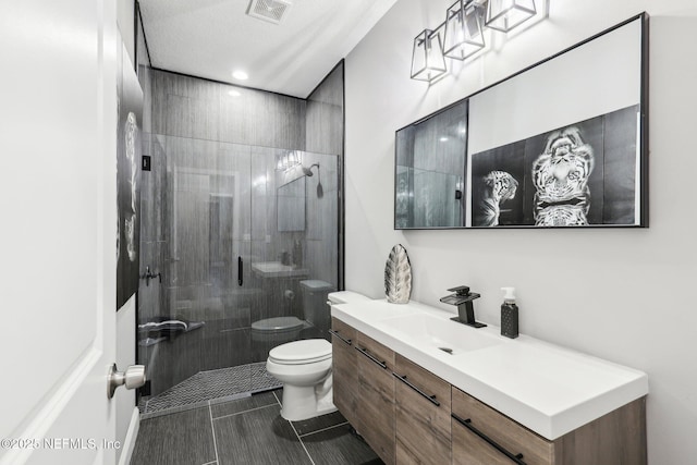 bathroom featuring visible vents, vanity, toilet, and tiled shower